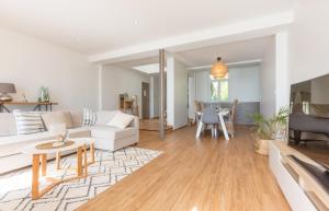 uma sala de estar com um sofá branco e uma mesa em Les Pieds Dans L'Eau - Bel appartement - Vue mer em Cancale