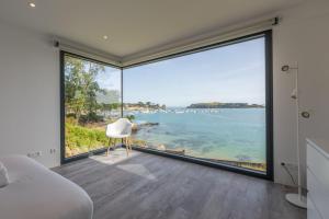 1 dormitorio con una gran ventana con vistas al océano en Villa Galeo - Maison d'exception à Rotheneuf en Saint-Malo