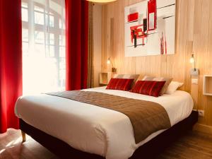 a bedroom with a large bed with red curtains at La Vieille Auberge du Lac in Saint-Agnan