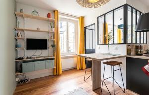 een thuiskantoor met een bureau en een televisie bij Lucelyne - Beau T2 rénové - Centre - Plage 400m in Dinard