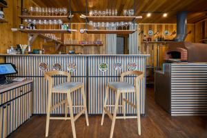 a bar with two stools in front of a counter at SKOGUR - Home & Resort in Bukovel