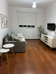 a living room with a couch and a table at Apartamento Centro ao lado do Country Club in Nova Friburgo