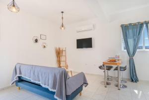 een kamer met een bed, een tafel en een tv bij Marvinas seaside apartments, Earth apartment & Ocean jacuzzi apartment in Kremasti