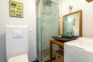 a bathroom with a sink and a glass shower at Le Capucin - Petit duplex avec place de parking in Dinard
