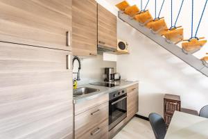 a kitchen with wooden cabinets and a staircase at Le Capucin - Petit duplex avec place de parking in Dinard