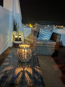 un balcon avec un banc et un vase sur une table dans l'établissement Condado Naranjos 5 Casa Kyle, à Murcie