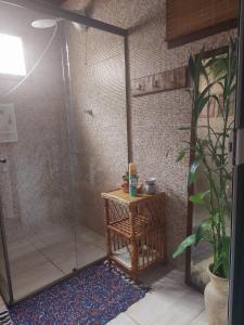 uma cabina de duche com uma mesa de madeira e uma cabina de duche em bambu em Residência Gato Branco em Imbituba