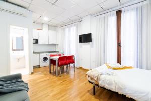 a bedroom with a bed and a table and a kitchen at Wekey Homes, Centro Granada Catedral in Granada