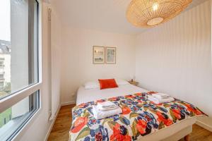 - une chambre avec un lit et une couverture colorée dans l'établissement Beaudelaire - Beau 2 chambres - Parking/Plage 400m, à Dinard
