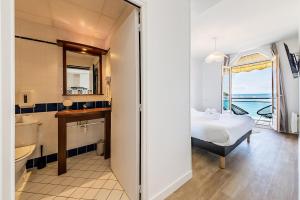 ein Schlafzimmer mit einem Bett und ein Bad mit einem Fenster in der Unterkunft Les Pieds Dans L'Eau - Appartment 2 - Vue mer in Cancale