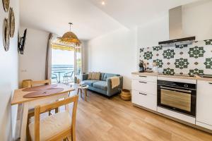 eine Küche und ein Wohnzimmer mit einem Tisch und einem Esszimmer in der Unterkunft Les Pieds Dans L'Eau - Appartment 2 - Vue mer in Cancale