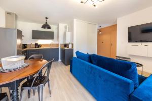 - un salon avec un canapé bleu et une table dans l'établissement L'Equinoxe, T2 de plain-pied dans résidence neuve., à Saint-Malo
