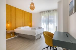 - une chambre avec un lit et un bureau dans l'établissement L'Equinoxe, T2 de plain-pied dans résidence neuve., à Saint-Malo