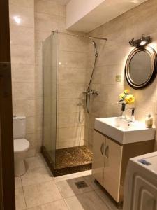 een badkamer met douche, wastafel en toilet bij M by the lake Mamaia Summerland in Mamaia