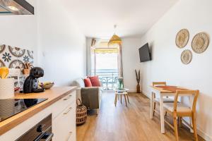 a kitchen and living room with a table and chairs at Les Pieds Dans L'Eau - Appartment 1 - Vue mer in Cancale