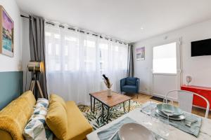 uma sala de estar com um sofá e uma mesa em L'ANTHRACITE, apartement rénové, tout confort em Saint-Jacques-de-la-Lande