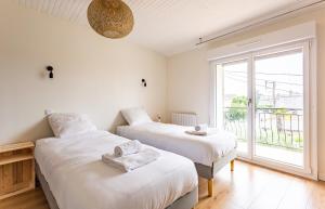 two beds in a room with a window at Saint Alexandre - Jolie maison atypique -Terrasse in Dinard