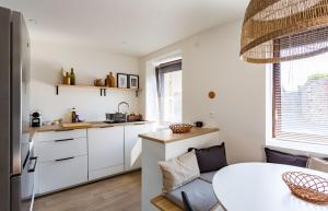 a kitchen with white cabinets and a table at Saint Alexandre - Jolie maison atypique -Terrasse in Dinard