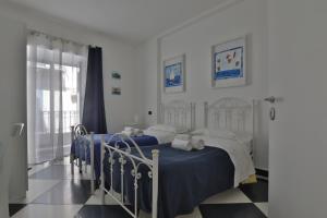 a bedroom with a bed with blue sheets and white pillows at Casa Galati in Palermo