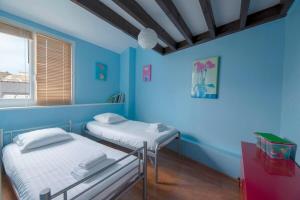 um quarto azul com duas camas e uma janela em L'Ancrage - Beau duplex 2 chambres - Plage à 5 min em Dinard
