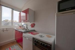 uma cozinha com um fogão, um lavatório e um frigorífico em L'Ancrage - Beau duplex 2 chambres - Plage à 5 min em Dinard