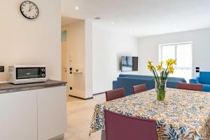 a room with a table with a vase of flowers at La Casa Azzurra, Levico Terme Ospitar in Levico Terme