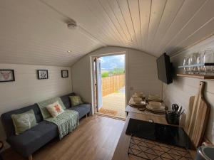 a living room with a couch in a tiny house at Cow Hill Pod in Fort William
