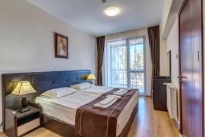 a bedroom with a large bed and a large window at Complex Kamelia in Pamporovo +64 photos