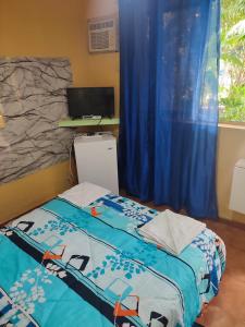 a bedroom with a bed and a desk with a laptop at Hotel Mango in Boca Chica
