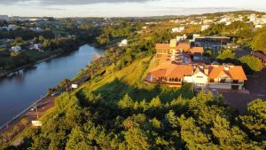 an aerial view of a house on a hill next to a river at Hotel Lago Dourado in Dois Vizinhos