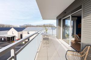a balcony with a view of a house at Le Magellan - logement neuf, parking, grand balcon in Dinard