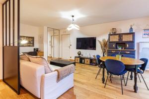 uma sala de estar com um sofá e uma mesa em Le Saint Cyr - bel appartement, parking & terrasse em Rennes