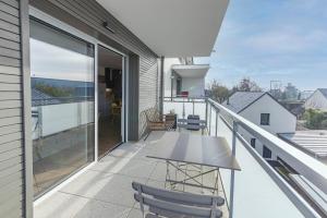 uma varanda com uma mesa e cadeiras em Le Magellan - logement neuf, parking, grand balcon em Dinard