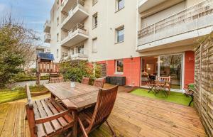 Le Saint Cyr - bel appartement, parking & terrasse في رين: سطح خشبي مع طاولة وكراسي خشبية