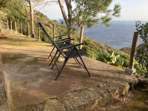 a bench sitting on the side of a path near the ocean at il patio mini appartamento in Pantelleria