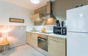a kitchen with a refrigerator and a microwave at Le Bacchus parking 1 chambre moderne -Tout confort in Rennes