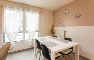 una mesa y sillas blancas en una habitación con ventana en Le Bacchus parking 1 chambre moderne -Tout confort en Rennes