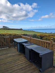 a picnic table on a deck with a view of the ocean at 64 Wide Horizon in Aberaeron