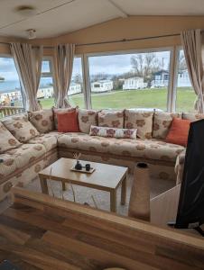 a living room with a couch and a tv at 64 Wide Horizon in Aberaeron