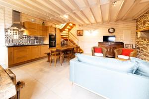 cocina y sala de estar con sofá y mesa en Minihic - Belle maison 3 chambres- Proche Mer, en Saint-Malo