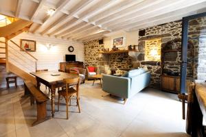 comedor con mesa y pared de piedra en Minihic - Belle maison 3 chambres- Proche Mer, en Saint-Malo