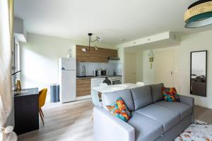 Il comprend un salon avec un canapé et une cuisine. dans l'établissement Les Asturies - Appartement rénové - Cosy moderne, à Rennes