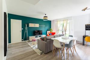 a living room with a couch and a table at Les Asturies - Appartement rénové - Cosy moderne in Rennes