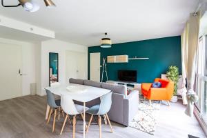 a living room with a table and a couch at Les Asturies - Appartement rénové - Cosy moderne in Rennes