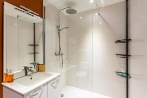 a white bathroom with a shower and a sink at Les Asturies - Appartement rénové - Cosy moderne in Rennes