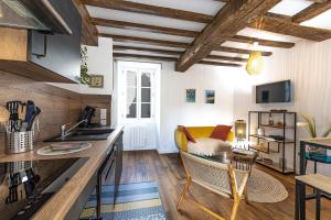 Il comprend une cuisine et un salon avec des plafonds en bois. dans l'établissement Le Petit Vauban - petit cocon rénové - proche, à Saint-Malo