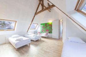 a attic room with two beds and a couch at Villa Asselin - Belle maison en pierre -4 chambres in Beaussais sur Mer