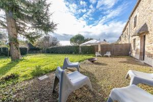 a backyard with white chairs and a fire pit at Villa Asselin - Belle maison en pierre -4 chambres in Beaussais sur Mer