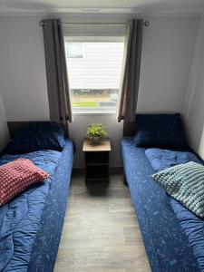 twee bedden in een kleine kamer met een raam bij Beach Resort Kamperland - 264 in Kamperland
