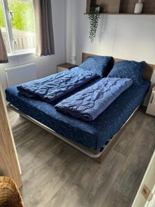 een bed met een blauw dekbed in een slaapkamer bij Beach Resort Kamperland - 264 in Kamperland